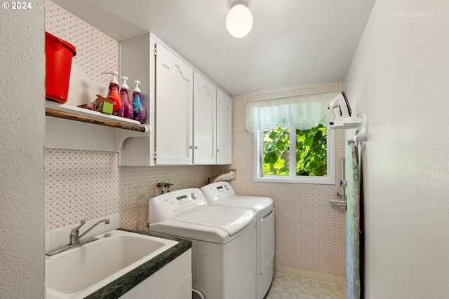 laundry area featuring washer and dryer, cabinets, and sink