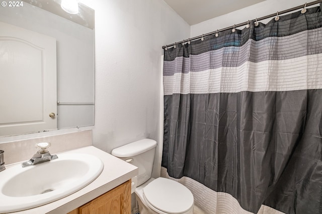 bathroom with toilet, curtained shower, and vanity