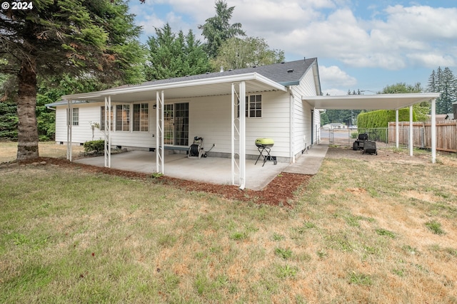 rear view of property featuring an attached carport, crawl space, fence, a yard, and a patio area