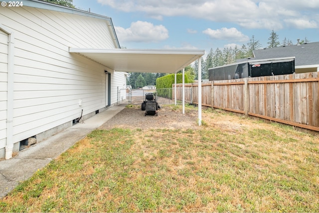 view of yard with fence and a carport