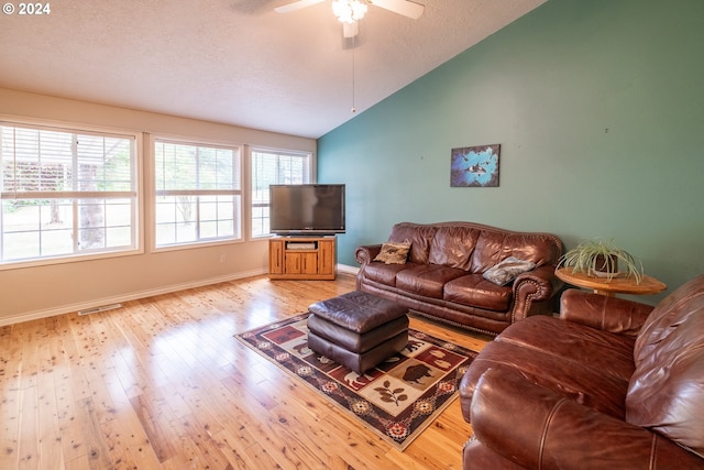 living room with lofted ceiling, a textured ceiling, light wood-style flooring, visible vents, and baseboards