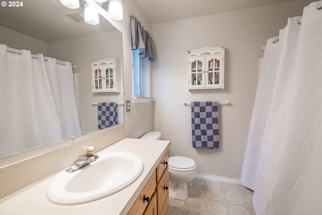 full bathroom featuring baseboards, vanity, and toilet