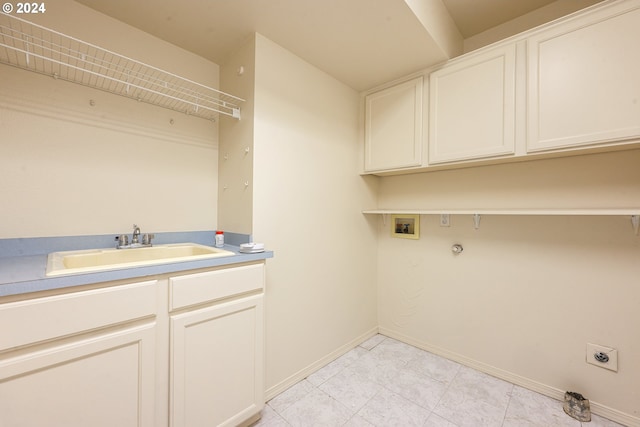 laundry room featuring hookup for a washing machine, hookup for an electric dryer, sink, light tile patterned floors, and cabinets