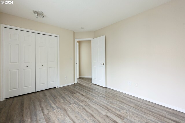 unfurnished bedroom with hardwood / wood-style floors and a closet