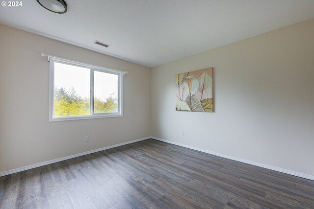 unfurnished room with dark hardwood / wood-style flooring