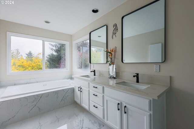 bathroom with vanity and a relaxing tiled tub