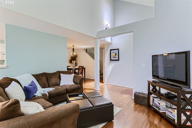 living room with light wood-type flooring and high vaulted ceiling