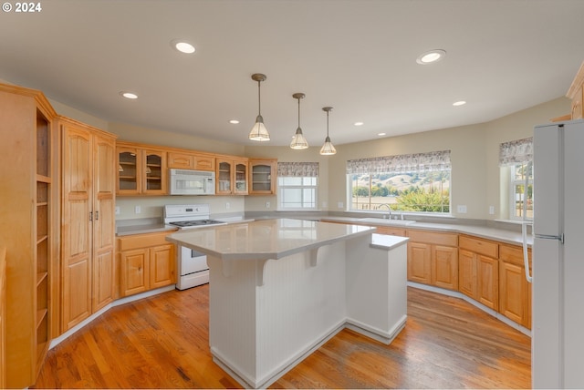 kitchen with white appliances, a kitchen island, light hardwood / wood-style flooring, light brown cabinets, and sink