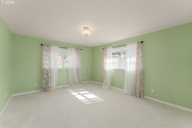 carpeted empty room featuring a wealth of natural light