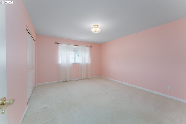 spare room featuring light carpet