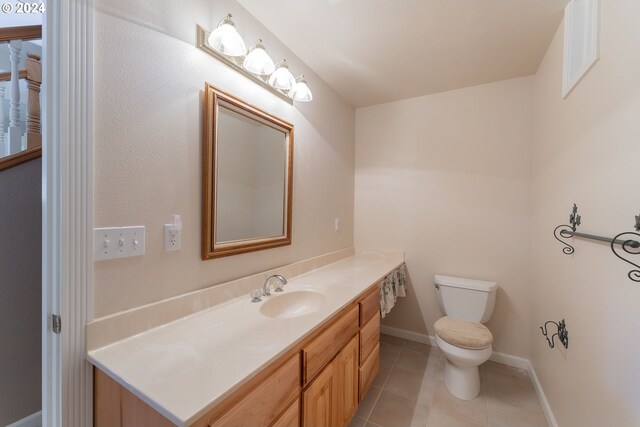 bathroom featuring tile patterned floors, vanity, and toilet