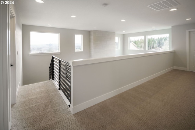 hallway featuring visible vents, baseboards, carpet, an upstairs landing, and recessed lighting