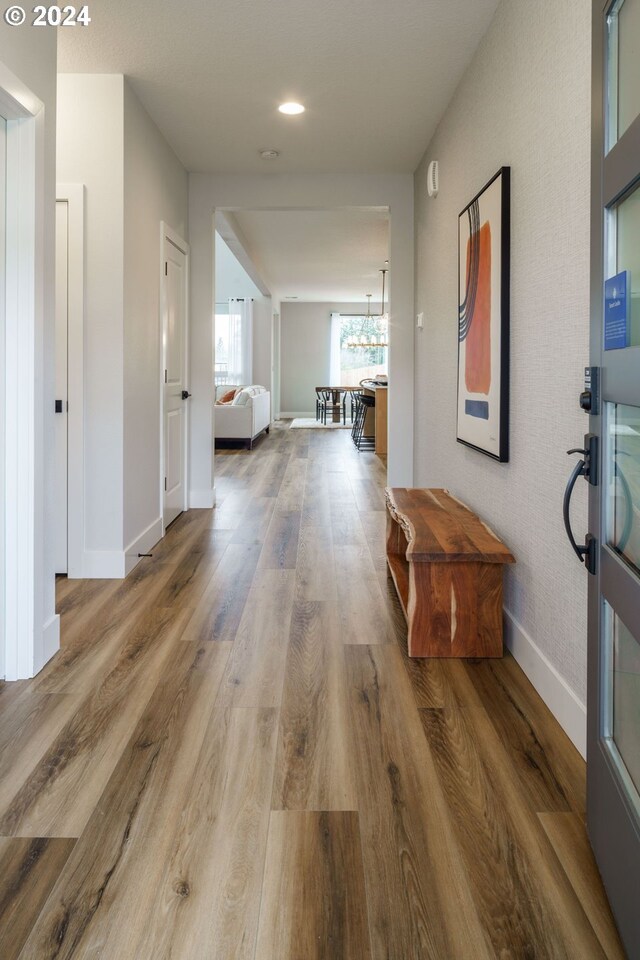 corridor with hardwood / wood-style flooring