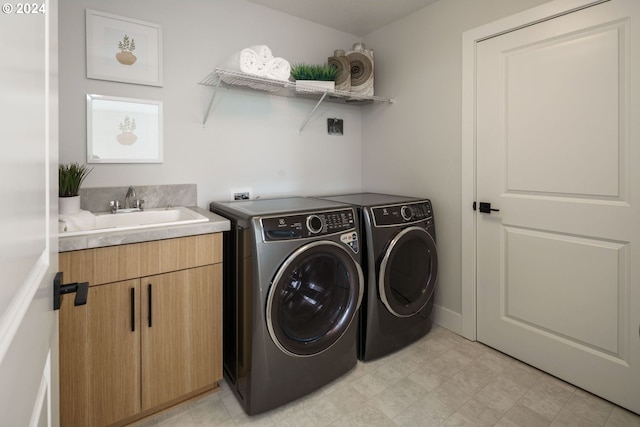 laundry room featuring light floors, separate washer and dryer, a sink, and cabinet space