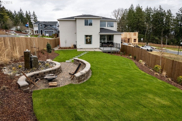 back of property with a yard, a patio area, and a fenced backyard