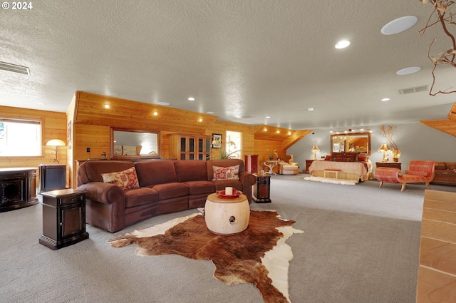 living room with wood walls, light carpet, and a textured ceiling