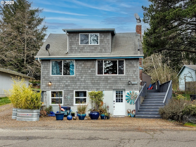 view of front facade with a chimney and stairs