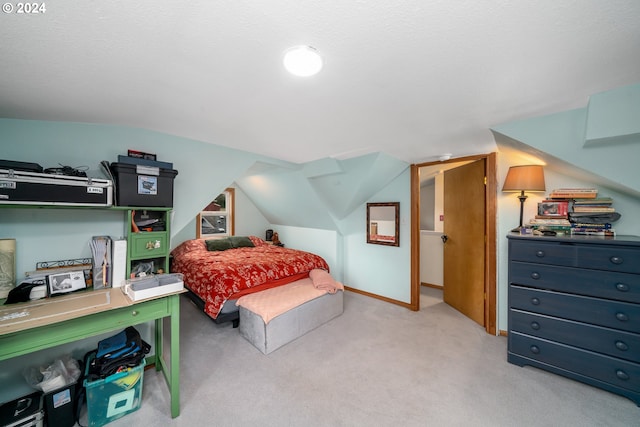 bedroom featuring light carpet, vaulted ceiling, and baseboards