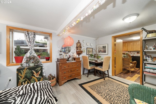 office area with light wood-style floors and crown molding