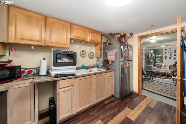 kitchen featuring dark wood-type flooring, freestanding refrigerator, light countertops, light brown cabinetry, and a sink