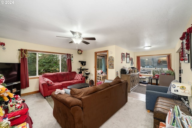 living area featuring a ceiling fan and baseboards