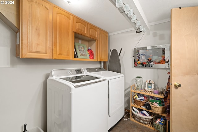 clothes washing area featuring washer and dryer, cabinet space, and crown molding