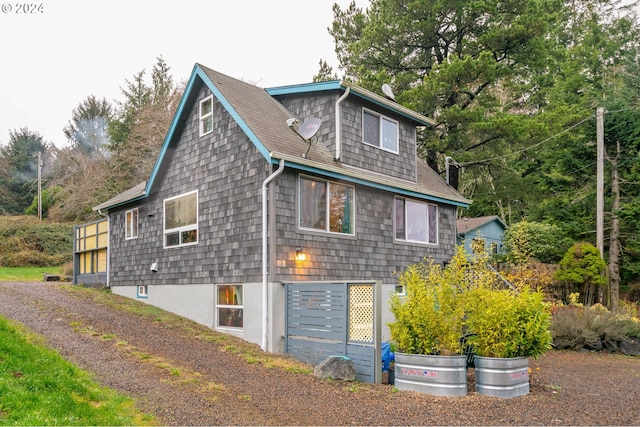 exterior space with a shingled roof and driveway