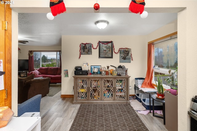 corridor with baseboards and wood finished floors