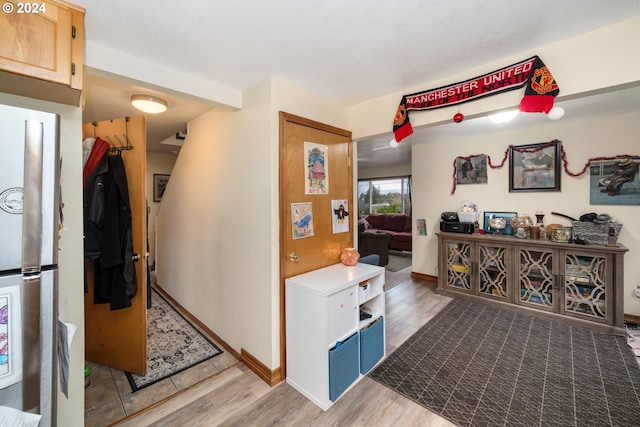 hall with baseboards and wood finished floors