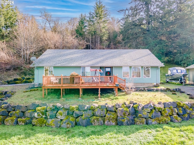 back of house with a deck and a yard