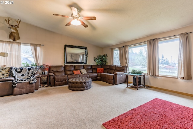 living room with ceiling fan, lofted ceiling, light colored carpet, and plenty of natural light