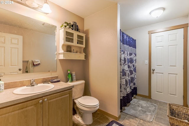 bathroom featuring toilet, tile floors, and large vanity