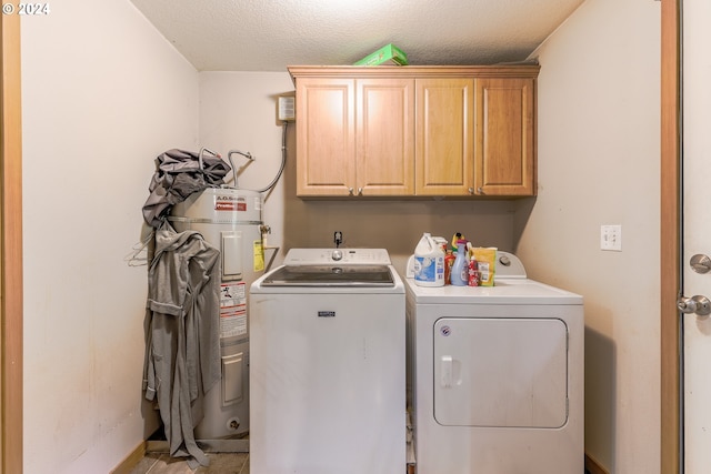 laundry room featuring electric water heater, independent washer and dryer, a textured ceiling, and cabinets