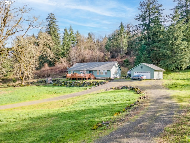 view of front of house featuring a front yard, an outdoor structure, a garage, and a wooden deck