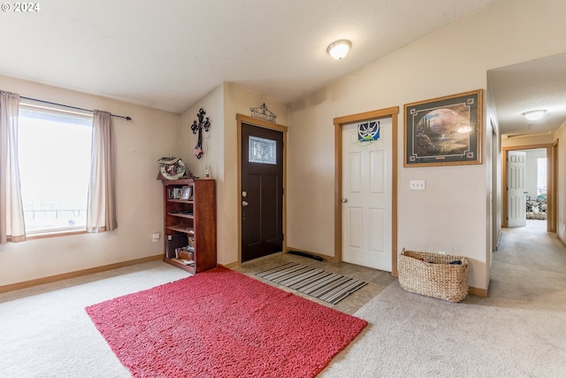 carpeted entrance foyer with lofted ceiling