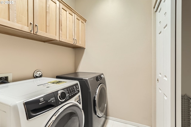 washroom featuring washer and dryer and cabinets