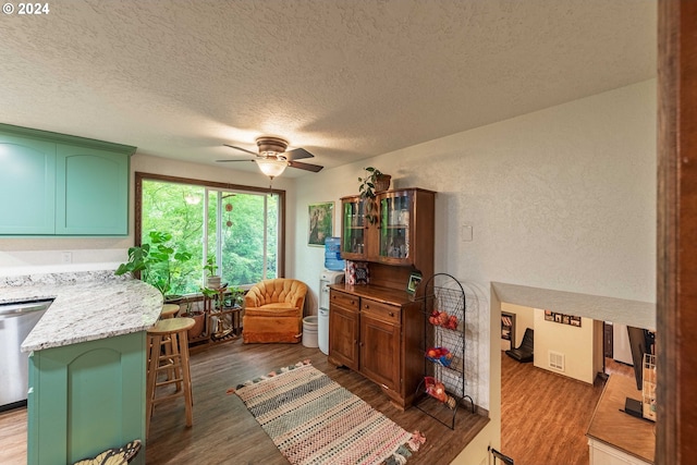 kitchen with dishwasher, wood-type flooring, a textured ceiling, and ceiling fan