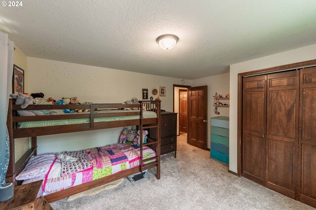 carpeted bedroom featuring a closet and a textured ceiling