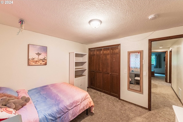 bedroom with a closet, a textured ceiling, and light colored carpet