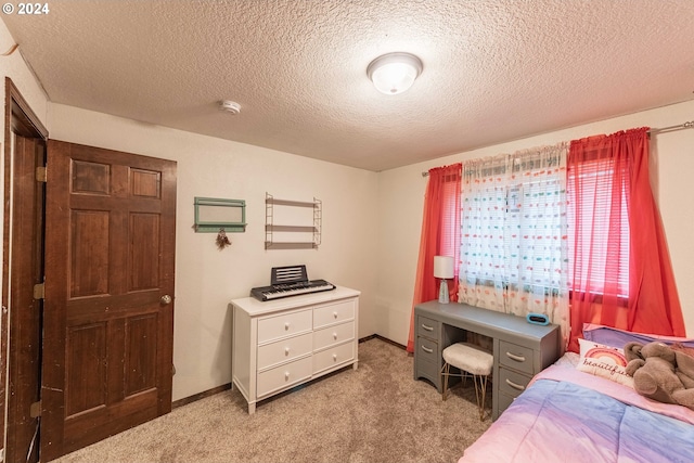 bedroom with a textured ceiling, carpet floors, and baseboards