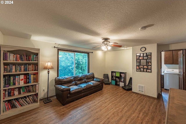 living room with visible vents, ceiling fan, wood finished floors, and washer / dryer