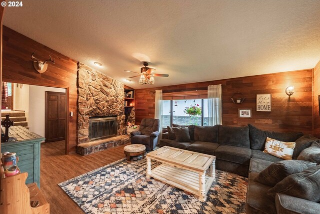 living room featuring wood walls, hardwood / wood-style floors, and a textured ceiling