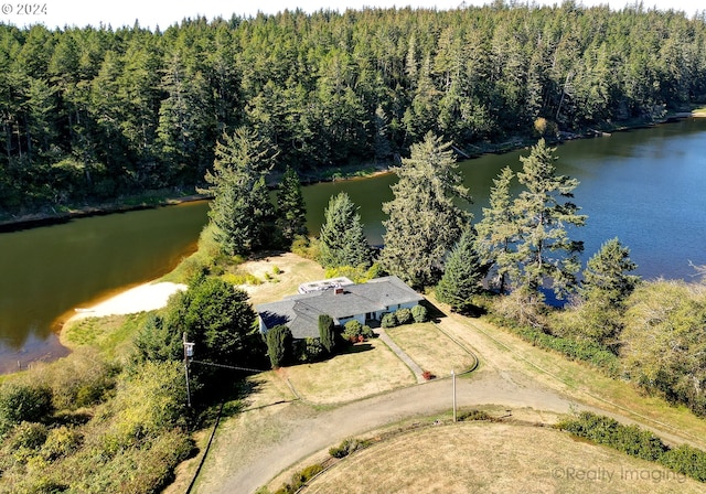 aerial view featuring a forest view and a water view