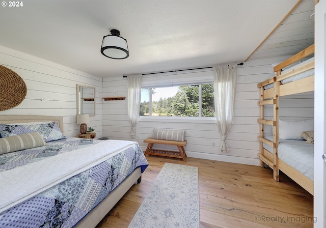 bedroom featuring light hardwood / wood-style flooring and wood walls