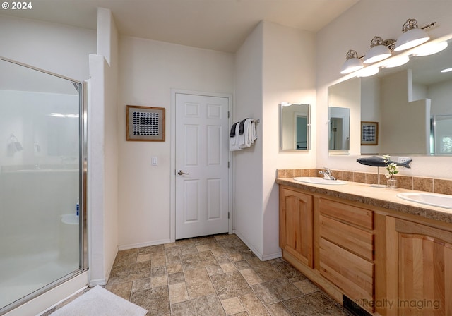 bathroom featuring a sink, a shower stall, and double vanity