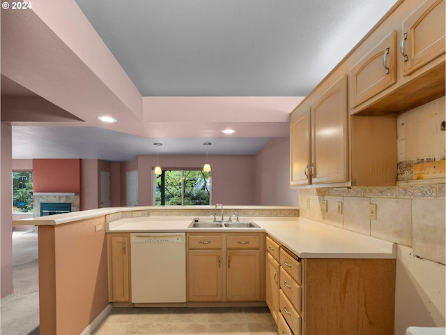 kitchen with recessed lighting, a peninsula, light countertops, white dishwasher, and a sink