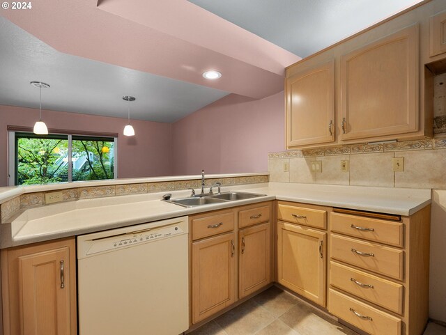 kitchen with light brown cabinets, sink, kitchen peninsula, white dishwasher, and decorative light fixtures