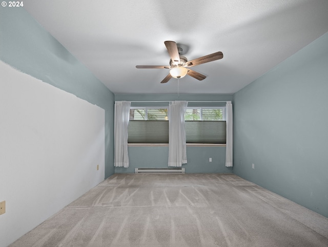 empty room featuring light colored carpet, baseboard heating, and ceiling fan