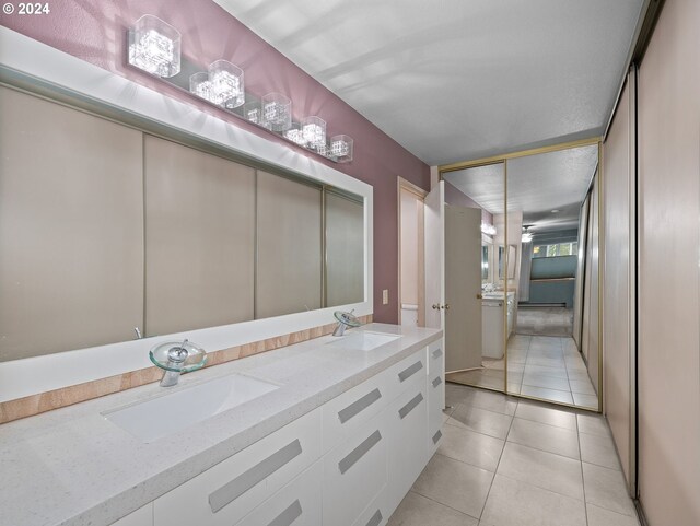 bathroom featuring tile patterned floors, double vanity, and a sink