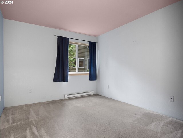 empty room with a baseboard radiator and carpet flooring